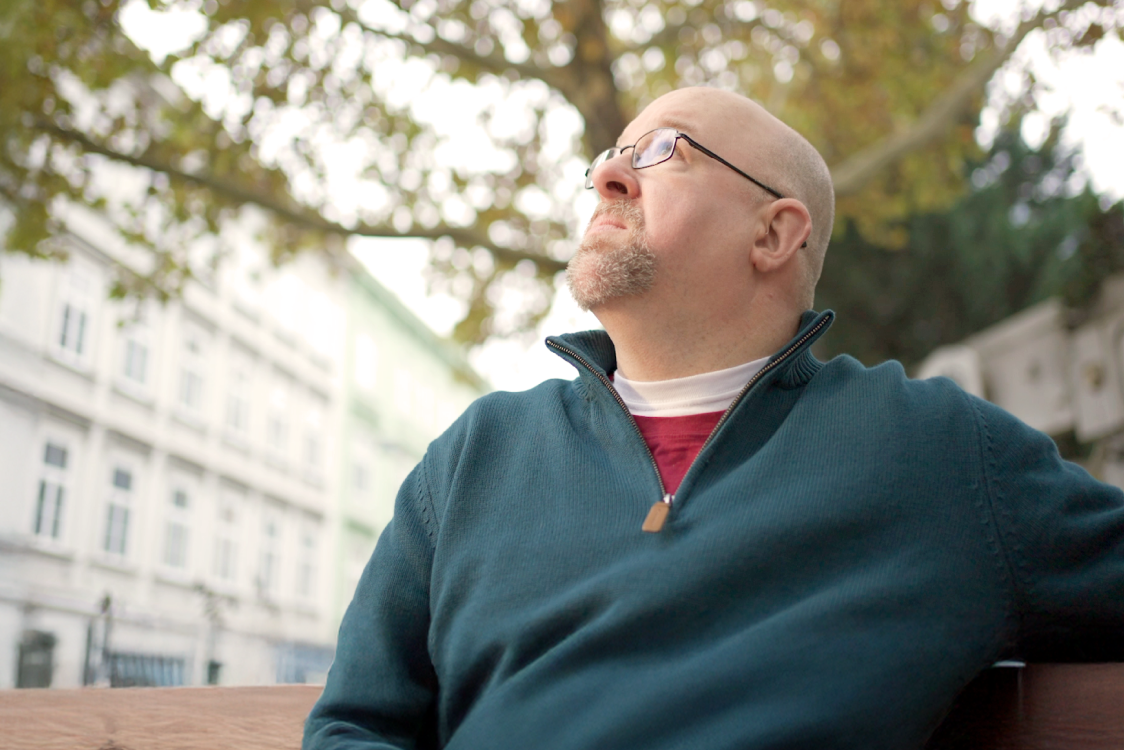 Man sitting on a bench staring up into the sky